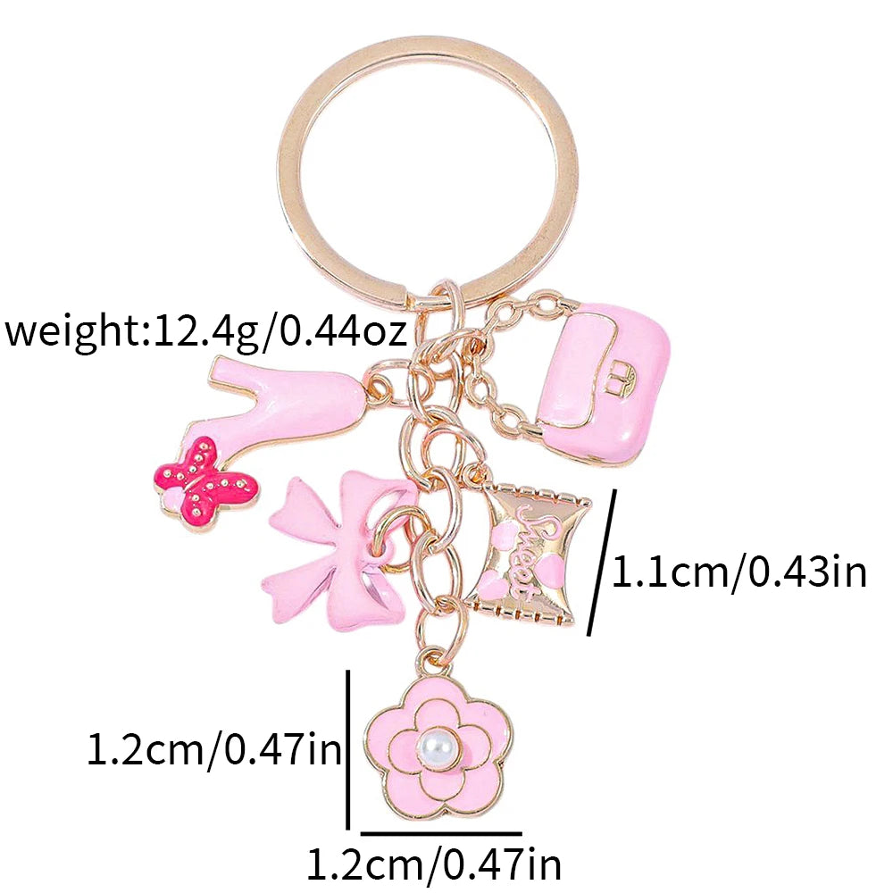 Pochette clé en forme de cœur rose avec un charm et un petit détail de perle.