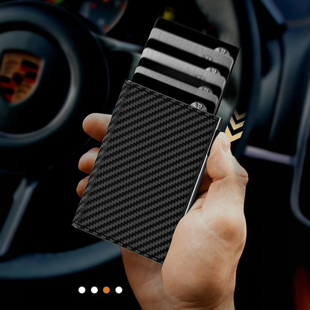 A hand holds a black carbon fiber magnetic card holder wallet with a card inserted, set against a car interior background.