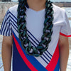 A young male wearing a chunky gold acrylic Cuban link necklace for men against an outdoor background.