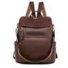 A brown vintage tassel backpack with anti-theft features is shown from the back.