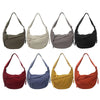 A collection of eight canvas crossbody bags in various earth tones including olive green, beige, gray, black, maroon, blue, y