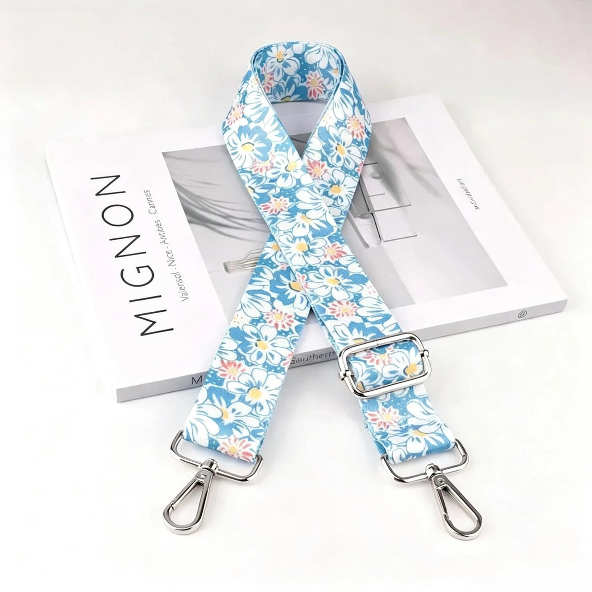 Blue and white floral patterned nylon crossbody bag strap with a silver metal buckle