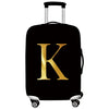 Black luggage with a gold letter K design and white handles