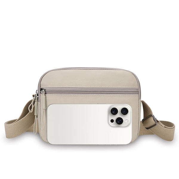 A beige nylon crossbody bag with a wide adjustable strap and a rectangular white phone holder.