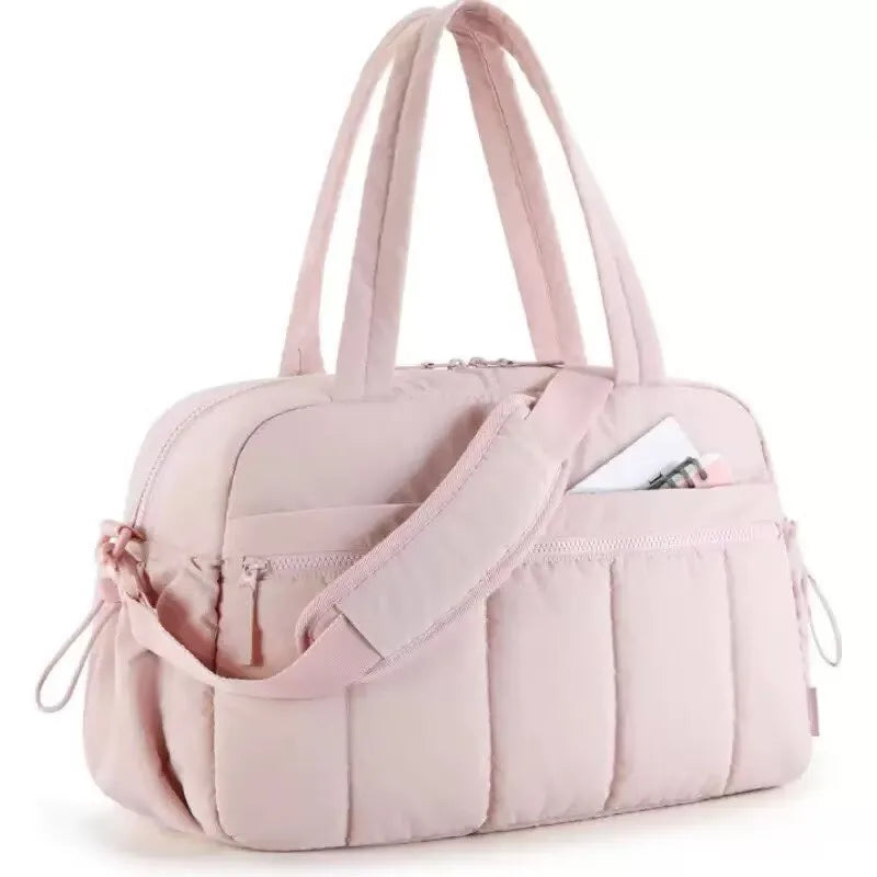 A light pink versatile large capacity travel and fitness bag with padded straps.