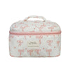 A white quilted cosmetic bag with pink trim and a floral pattern, featuring a handle.