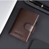 A dark brown leather card holder with a pop-up slide feature resting on a dark surface.