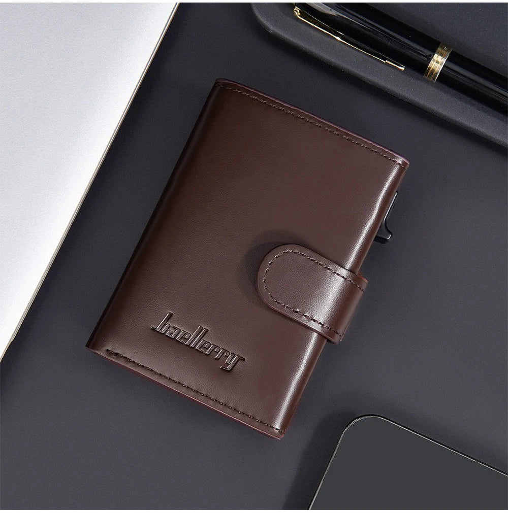 A dark brown leather card holder with a pop-up slide feature resting on a dark surface.