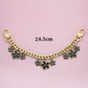 Gold chain necklace with black flower charms and a gold clasp, measuring 24.5cm.