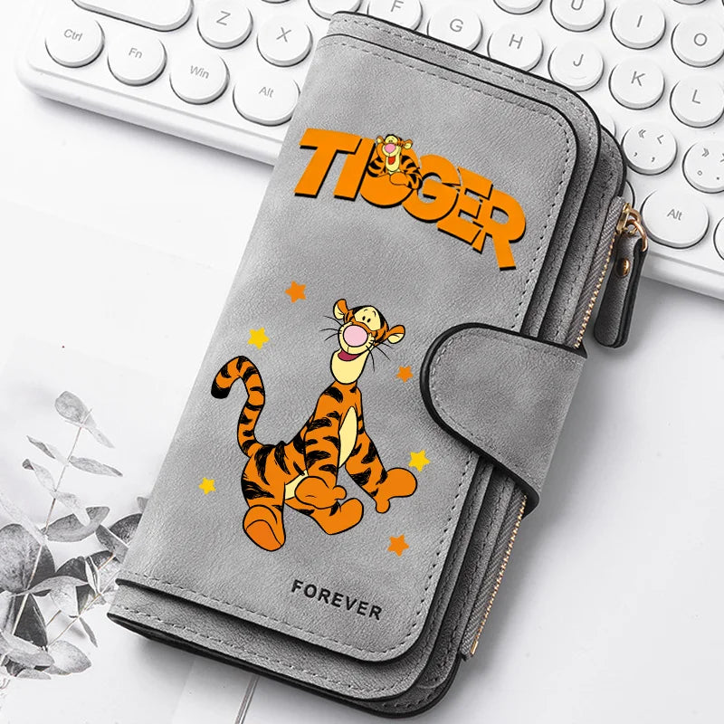 A gray zippered pouch featuring a tiger graphic on the cover, resting on a white background next to a laptop keyboard.