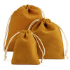 Un juego de tres bolsas de regalo de terciopelo amarillo mostaza con cordel natural.