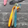 A collection of colorful adjustable soft lure fishing tackle, including orange, green, and blue lures.