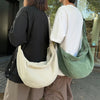 A woman wearing a black shirt and light pants holds a beige corduroy casual crossbody shoulder bag.