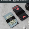 A black pop-up card wallet is shown next to a stack of US hundred dollar bills on a white textured surface.