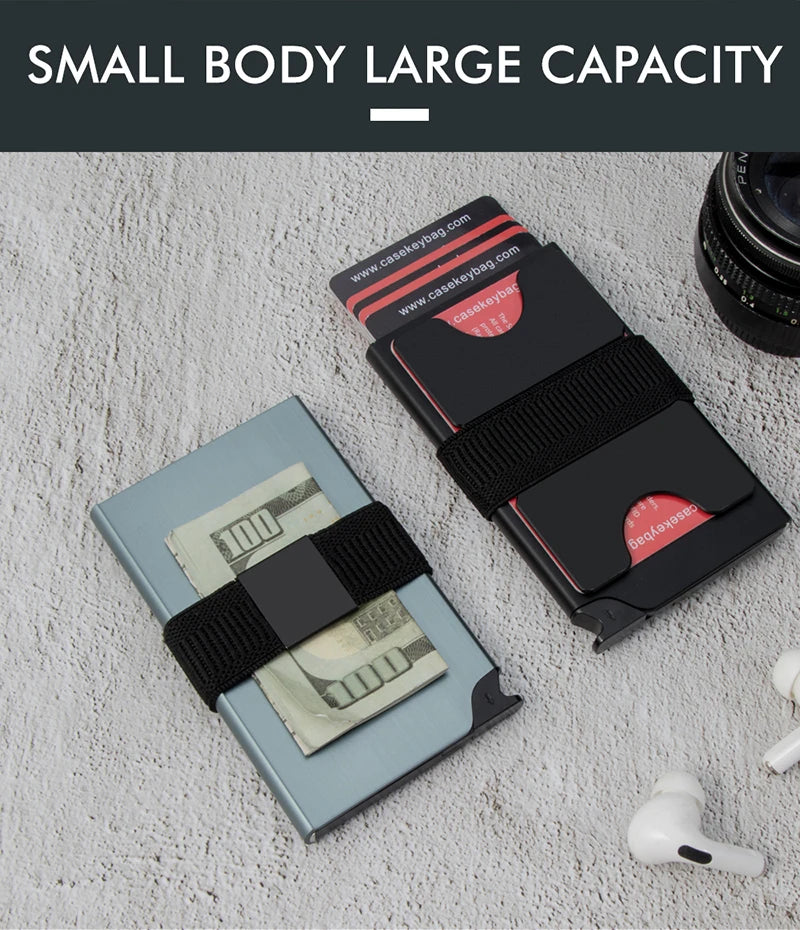 A black pop-up card wallet is shown next to a stack of US hundred dollar bills on a white textured surface.