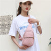Eine Frau trägt ein rosa gestepptes, wasserdichtes Crossbody-Sling-Bag mit einem weißen T-Shirt.