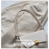 A light beige leather crossbody bag with a woven strap and gold hardware shown against a neutral background.