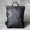 A black genuine full-grain leather backpack shown from the back.