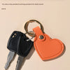 A set of keys attached to an orange leather heart pendant keychain.
