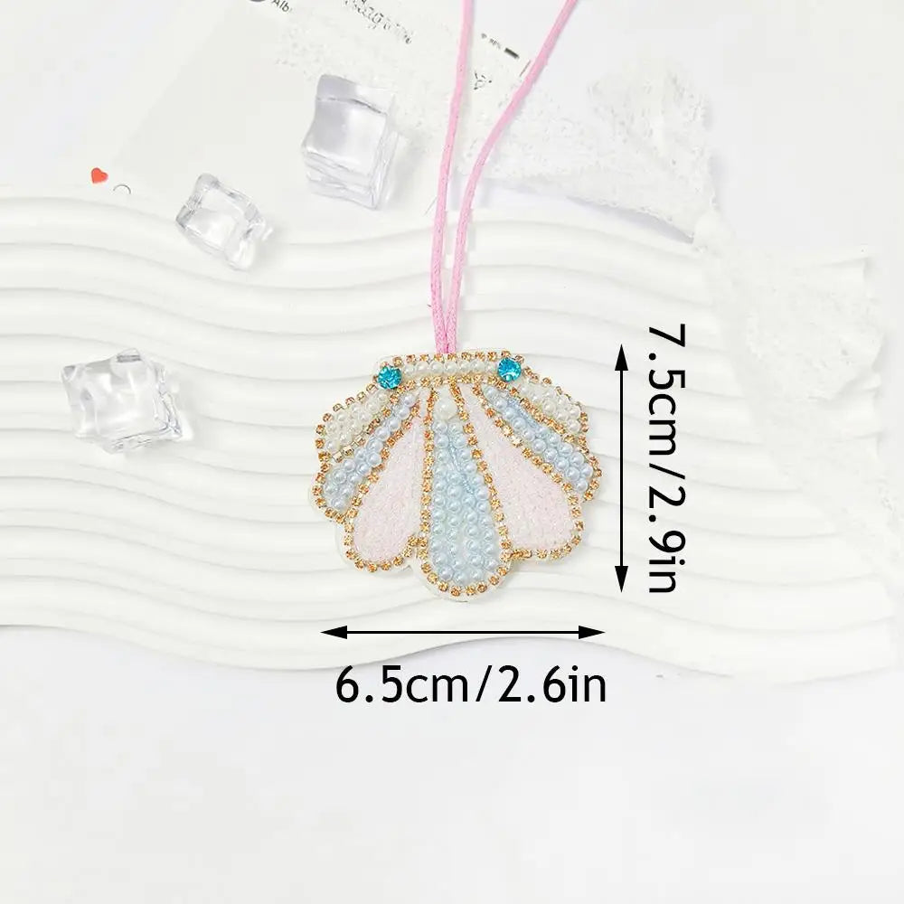 Hand sewn rhinestone beaded bag charm with a pink cord and white background