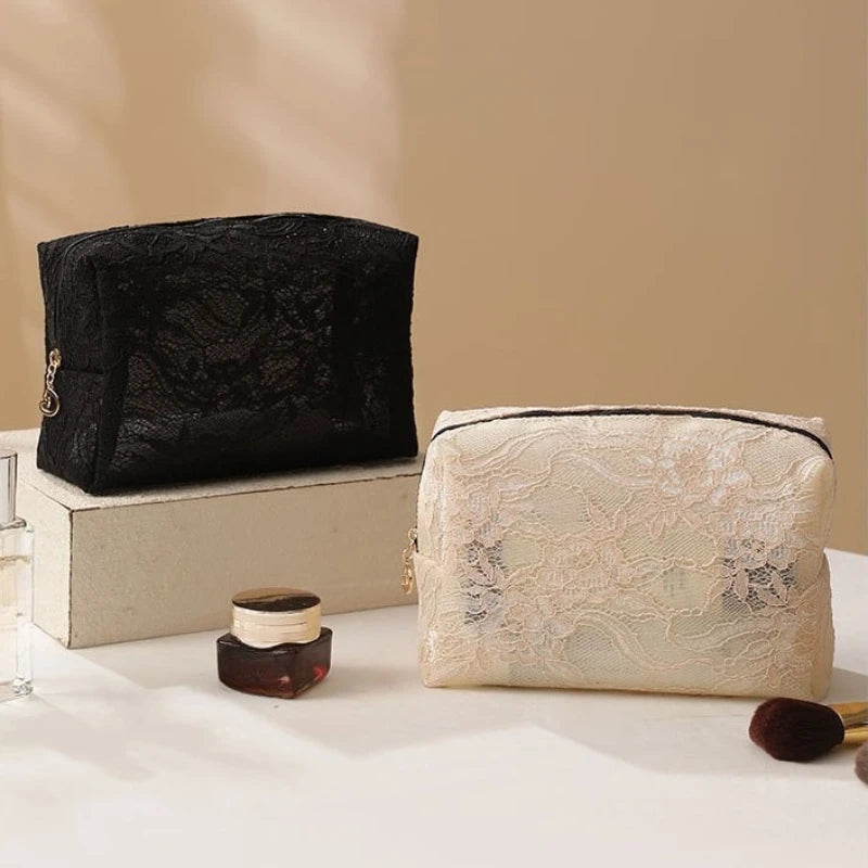 A black lace mesh cosmetic and jewelry organizer bag resting on a light wooden box.