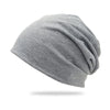 A gray slouchy knit beanie hat shown from the side.