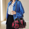 A woman wearing a blue shirt and black pants holds a spacious pink and black leopard print PU leather tote bag.