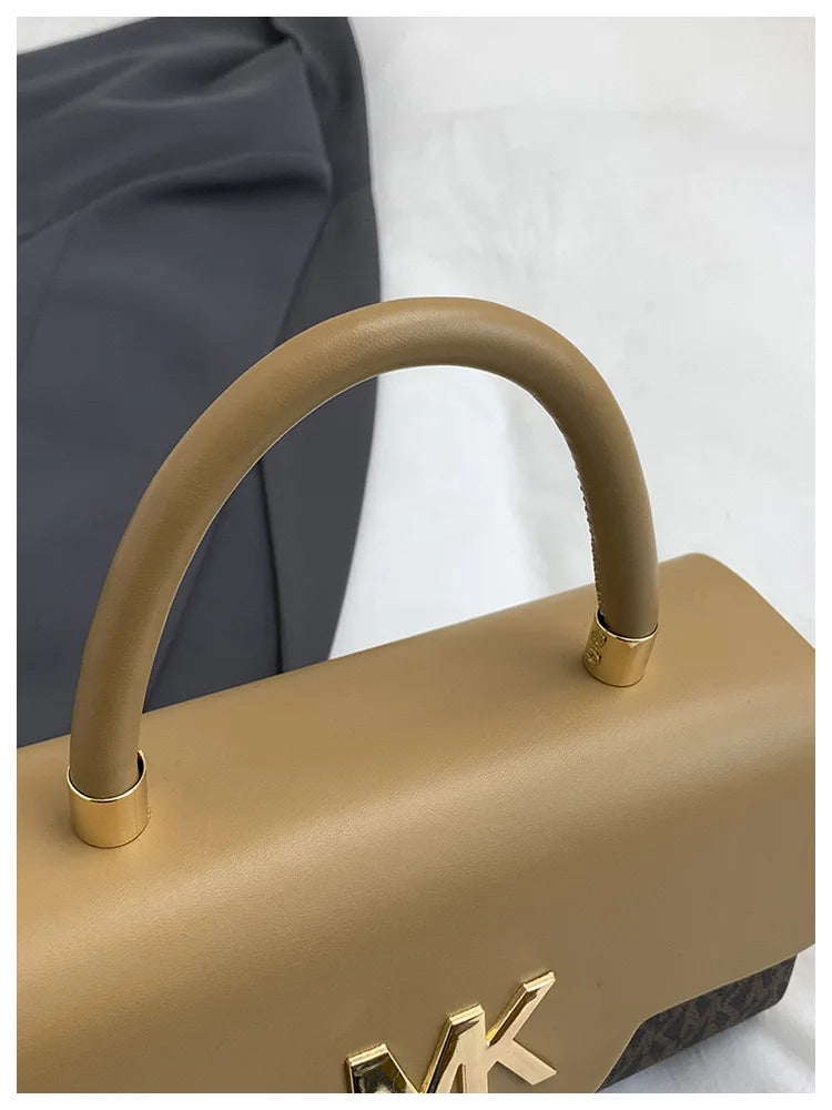 A tan Michael Kors classic letter square crossbody bag with a smooth leather handle and gold hardware.