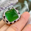A luxury leopard crystal statement ring featuring a green faceted gemstone surrounded by sparkling silver-toned stones.