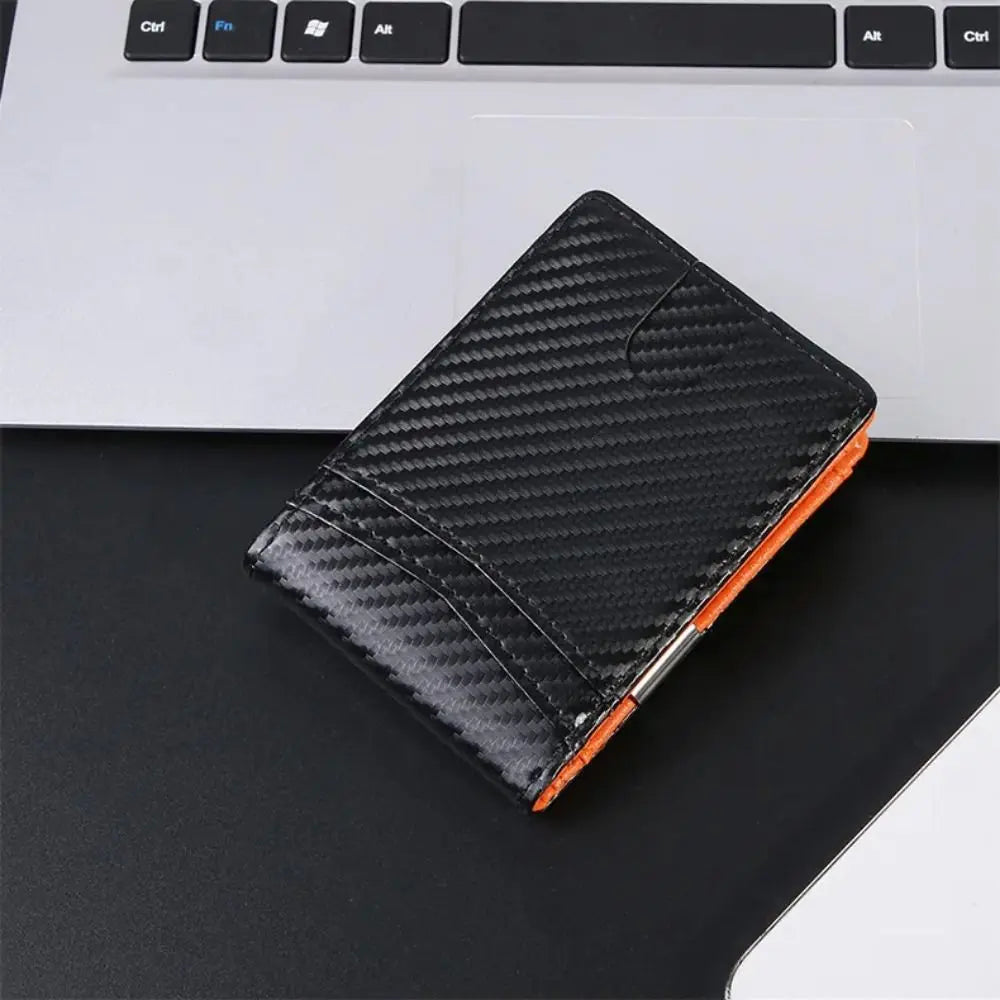A black textured wallet with an orange accent resting on a dark surface.