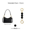 Black extended chain accessory with a small black leather bag and gold rings