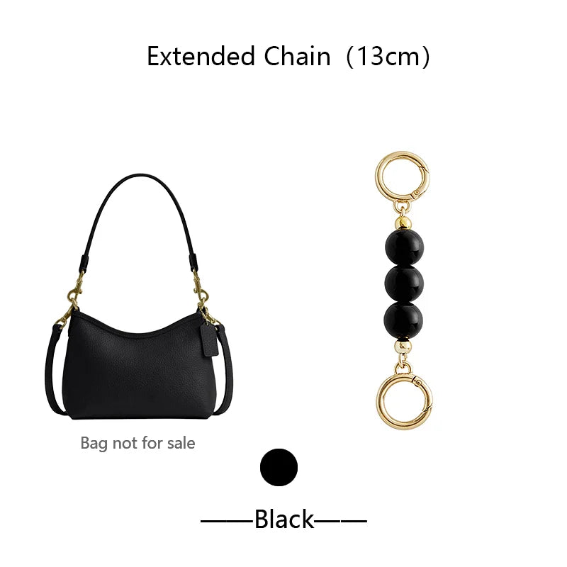 Black extended chain accessory with a small black leather bag and gold rings