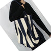 A person holds a striped canvas tote bag with an inner pocket against a white background.