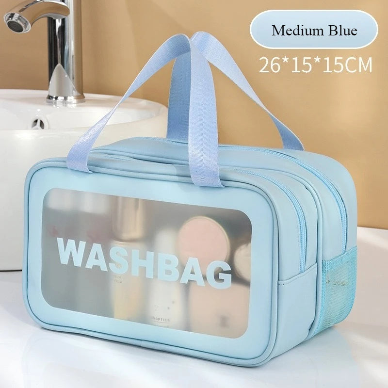 Light blue double-layer clear wash bag with a ribbon, shown next to a sink.