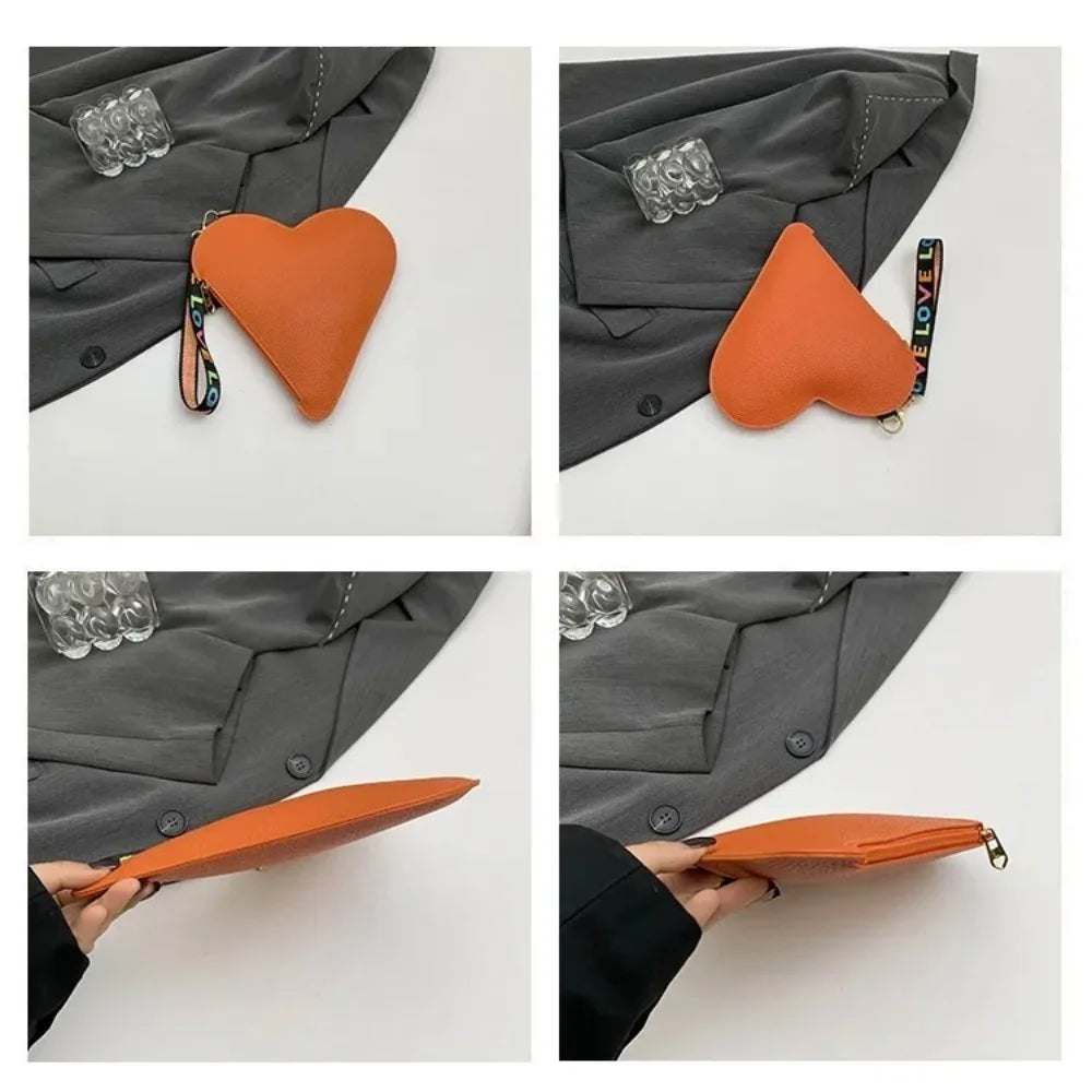 Cartera de monedas con forma de corazón naranja de PU mostrada contra una manga de chaqueta gris.