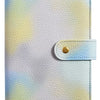 A light purple and yellow watercolor patterned leather notebook cover with a gold snap closure.