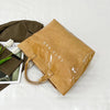 Una bolsa de tela de PVC minimalista color marrón junto a un artículo de tela verde oliva oscuro.