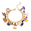 A gold chain bracelet featuring various Halloween charms including a pumpkin, ghost, and witch hat.