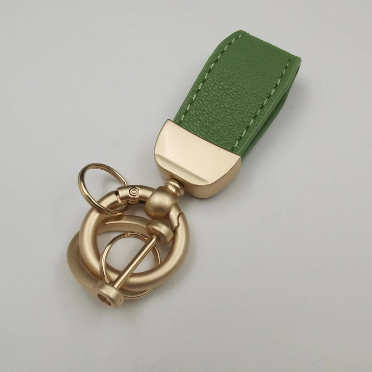 Echtes Leder-Schafnier-Auto-Schlüsselanhänger mit grünem Band und Messing-Hardware.