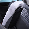 A black car seat armrest featuring a plush, white faux fur cushion.