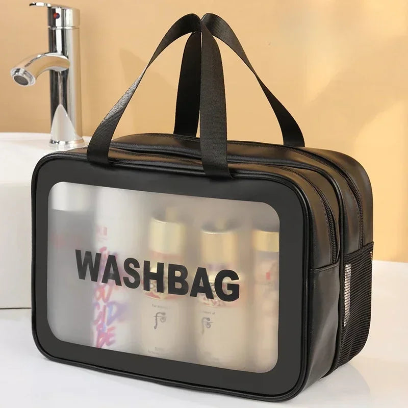 A black washbag with a clear window is shown next to a kitchen faucet.