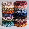 A stack of 19 thin scrunchies hair ties in various shades of pink, purple, green, and blue.