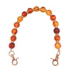 Handcrafted resin stone bead bag chain featuring round, translucent orange and amber beads.