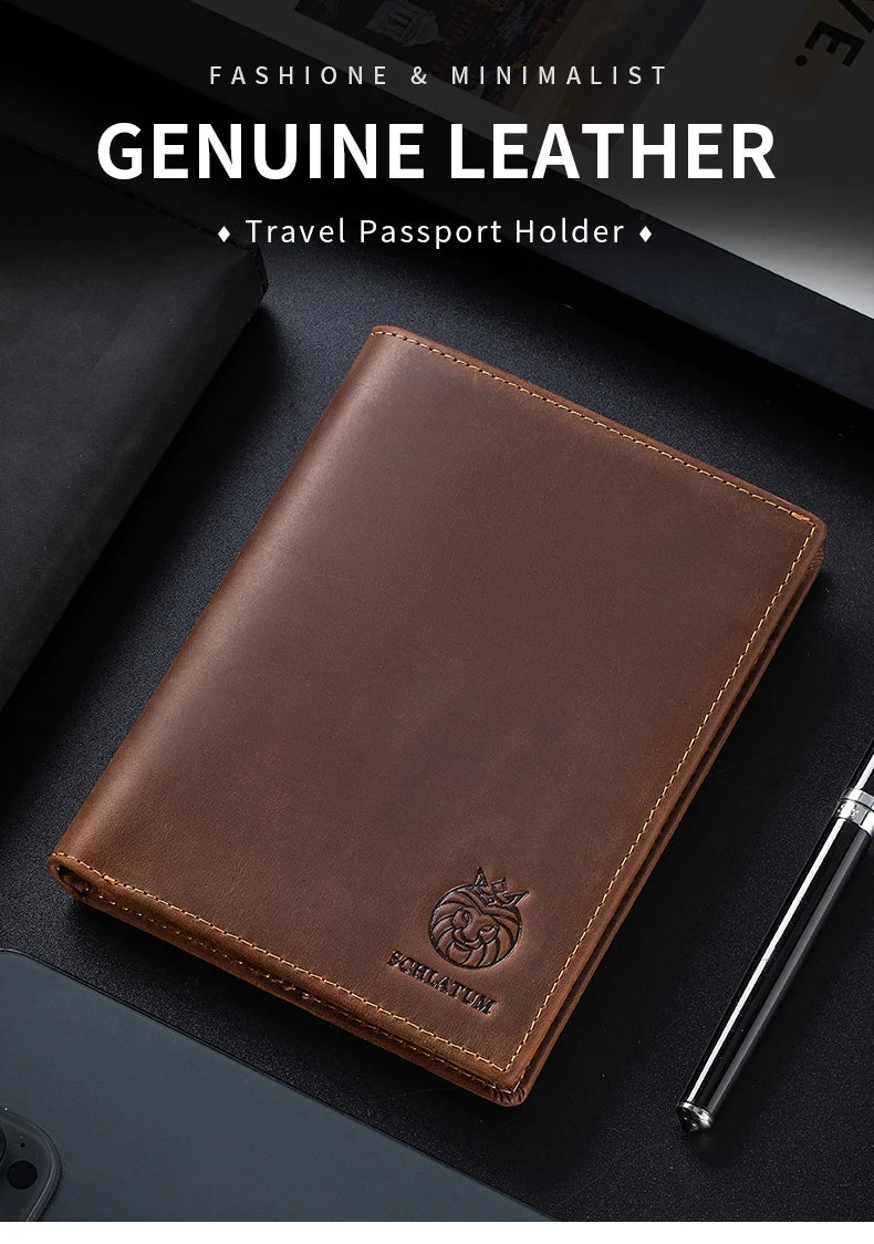 A brown genuine leather passport holder is shown resting on a dark surface next to a pen.