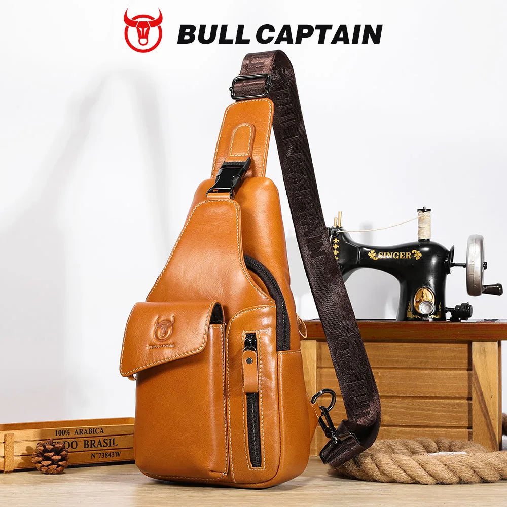 A brown leather sling backpack with a dark strap and a Singer sewing machine is displayed on a wooden surface.