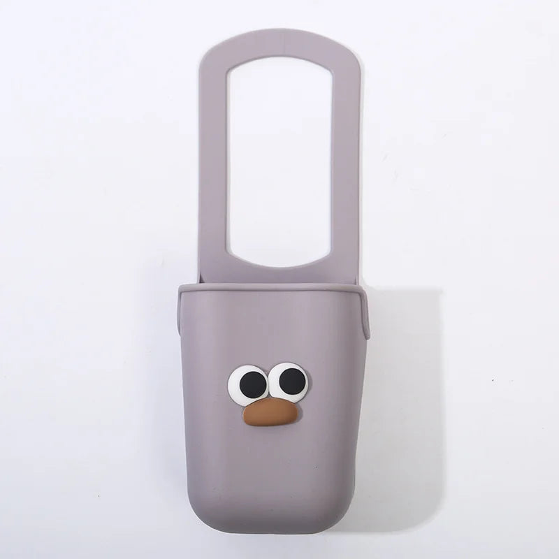 A light purple silicone cup holder with a cute face design.