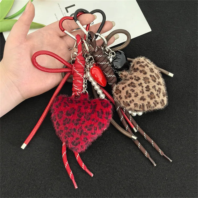 A collection of leopard print plush love pendants and keychains with various colored cords and beads.