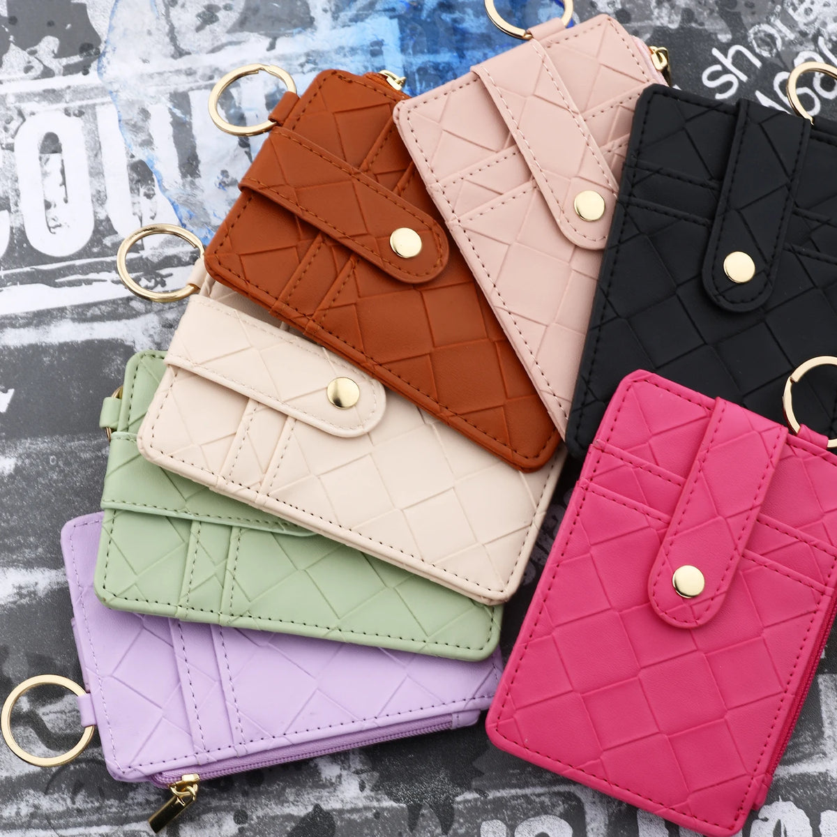 A collection of five quilted PU leather card holder wallets in various pastel and earth tones displayed on a dark surface.