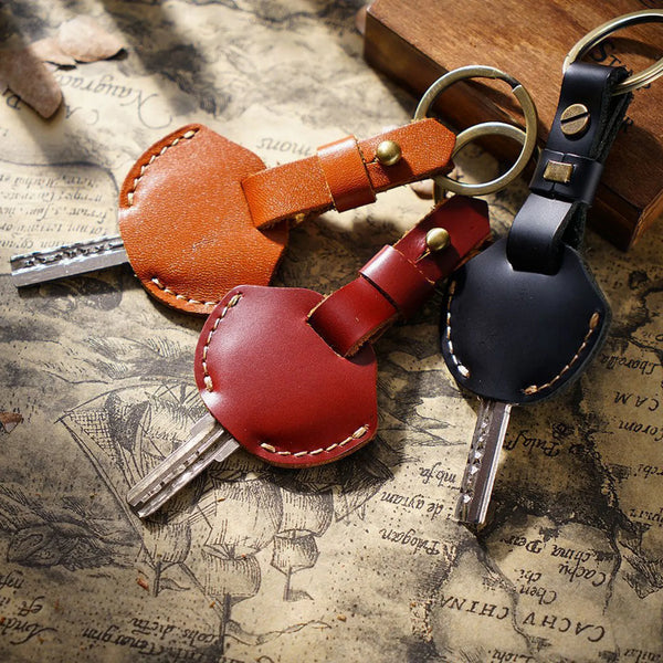 A genuine leather key fob cover with a keychain ring, featuring brown and dark red leather accents.