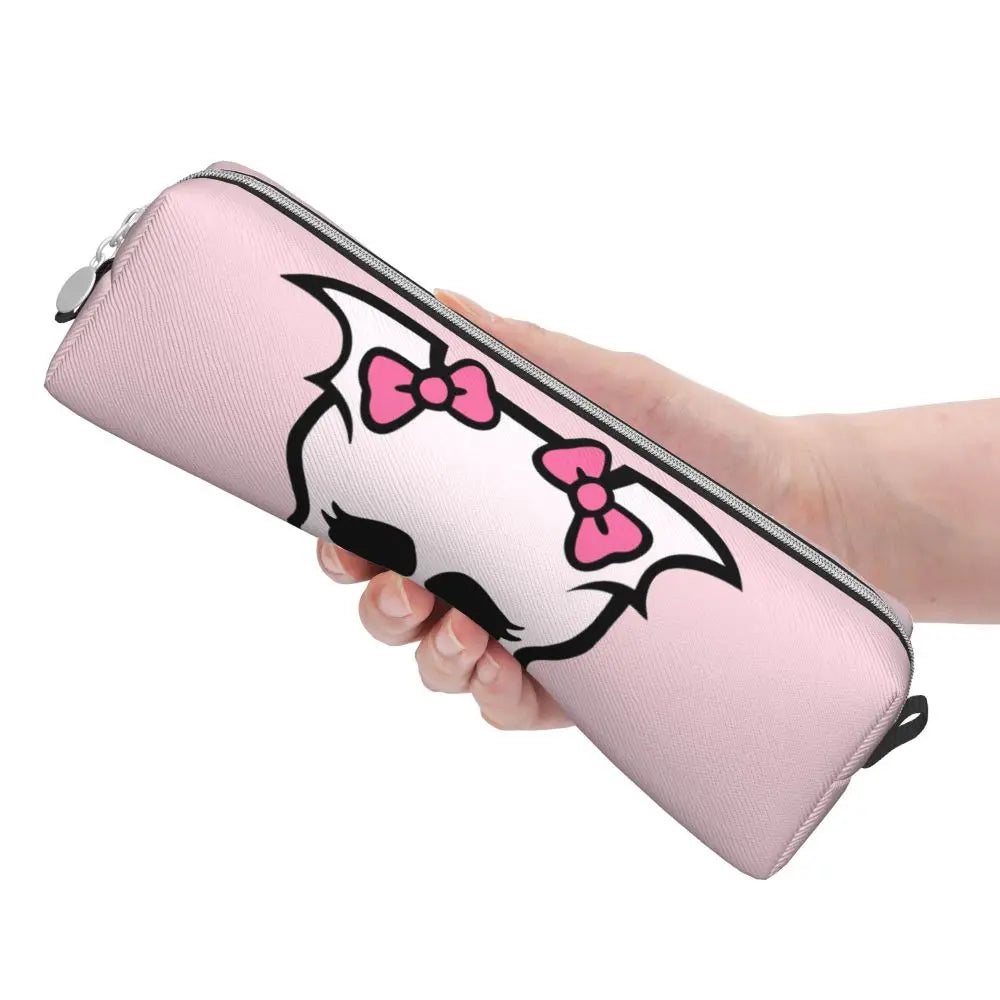 A hand holds a pink pencil case featuring a black and pink bat-like design with a bow detail.